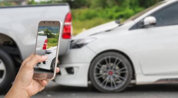 Man using his smartphone to take a photo of a rear-end collision between a pickup truck and a sedan | Colombo Law