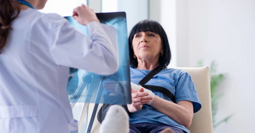 doctor showing injured female patient an X-ray after an accident