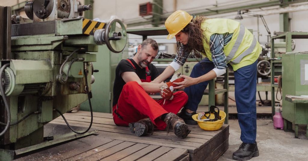 woman in hardhat helping coworker who suffered injury on the job Columbus work injury lawyer