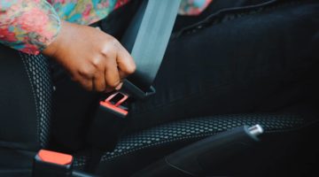 young woman buckling her seat belt