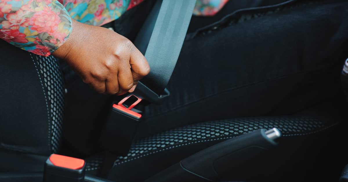 young woman buckling her seat belt