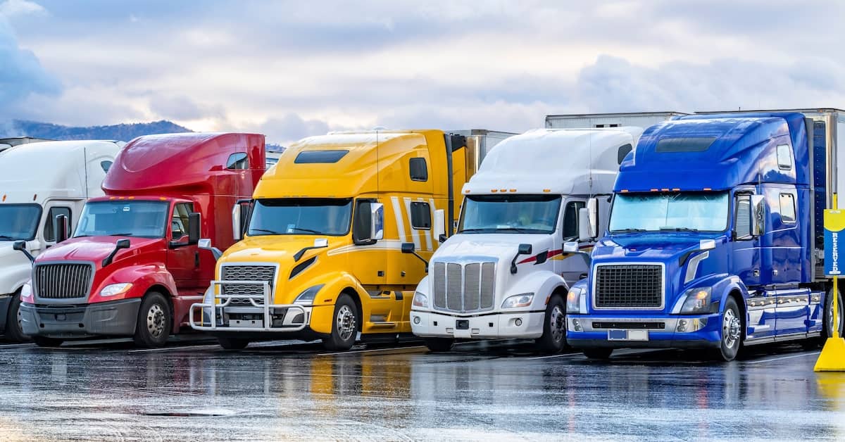 Line of semi-trucks in a trucking company lot | Colombo Law
