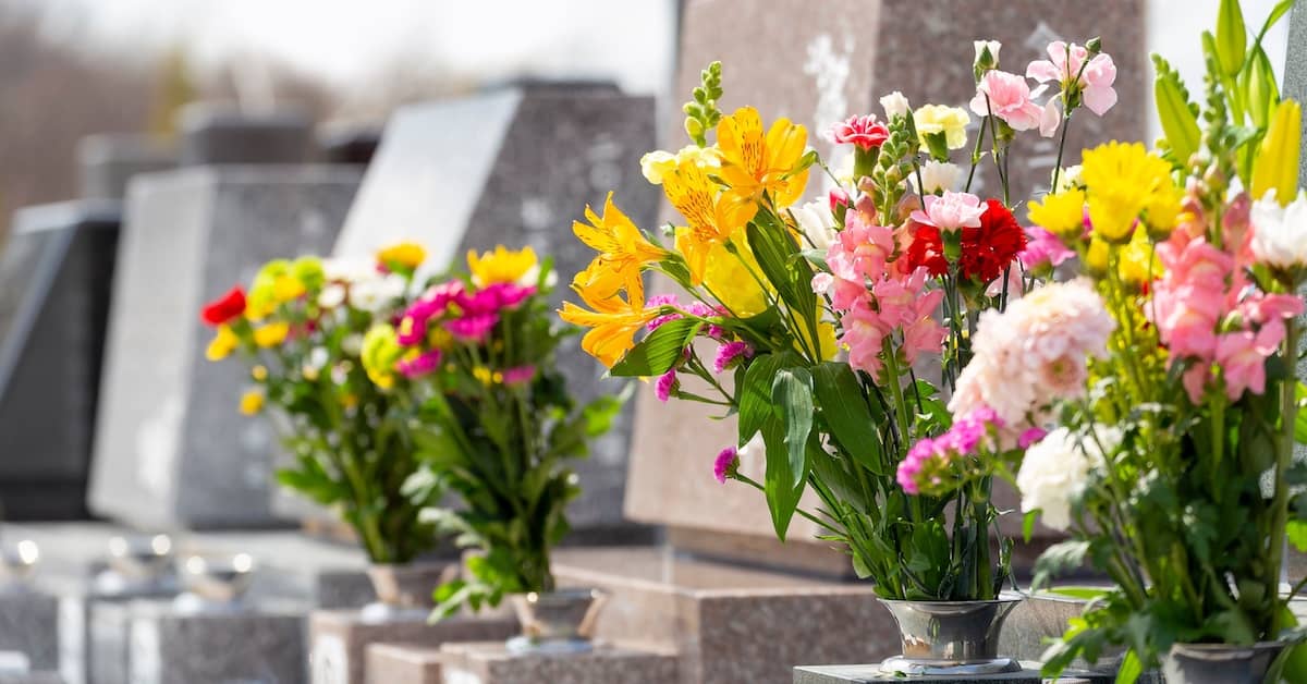 Flowers at a grave site in a cemetery | Colombo Law