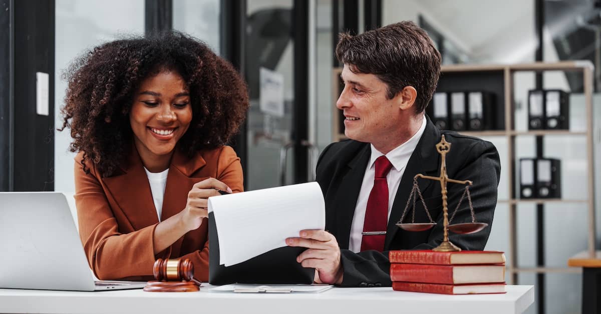 Woman meeting with a personal injury lawyer in Columbus at his desk | Colombo Law