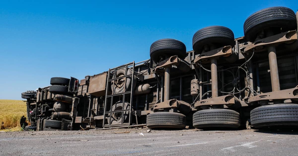 Underside of an 18-wheeler truck turned over on its side after an accident | Colombo Law