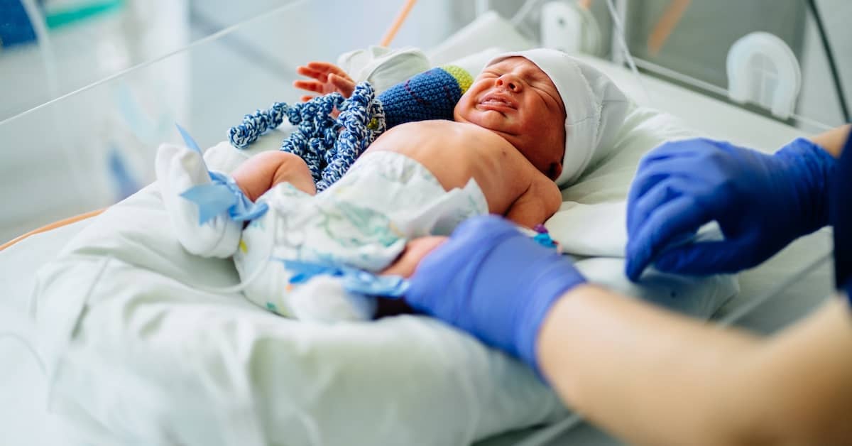 Crying baby receiving medical care in a neonatal intensive care unit | Colombo Law